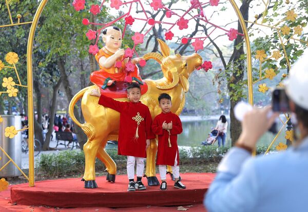 Nhiều người dân vẫn không đeo hoặc bỏ khẩu trang khi chụp hình lưu giữ kỷ niệm tại các địa điểm công cộng, đông người (ảnh chụp chiều 30 Tết tại Hồ Hoàn Kiếm). - Sputnik Việt Nam