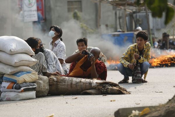 Nhà sư cầm ống nhòm ở sau chướng ngại vật trên đường phố Mandalay, Myanmar - Sputnik Việt Nam