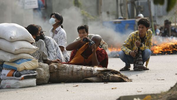 Nhà sư cầm ống nhòm ở sau chướng ngại vật trên đường phố Mandalay, Myanmar - Sputnik Việt Nam