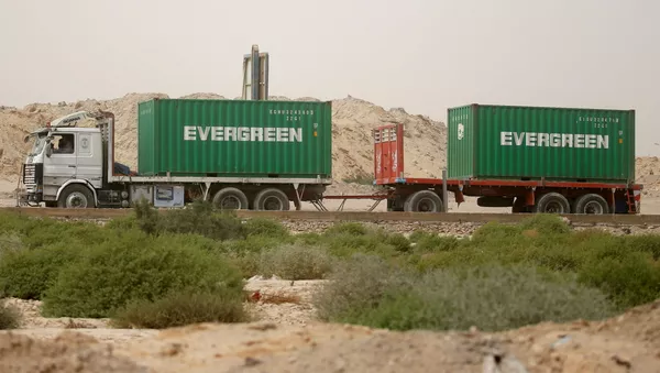 Một chiếc xe tải chở container Evergreen, chờ đi qua cổng chính của cảng El Ain El Sokhna đến Kênh đào Suez, Ai Cập ngày 24 tháng 3 năm 2021 - Sputnik Việt Nam