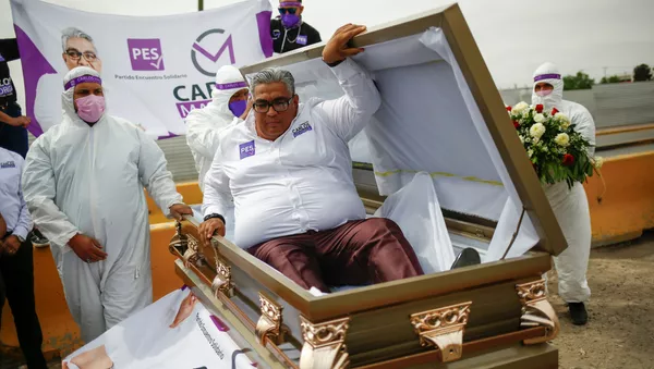 Chính trị gia Carlos Mayorga diễu khắp thành phố trên chiếc xe tang, còn bản thân ông ta nằm trong quan tài. - Sputnik Việt Nam