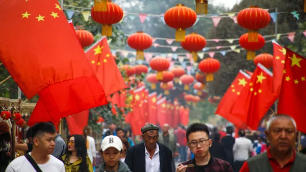Mọi người đi ngang qua quốc kỳ Trung Quốc ở Kashgar - Sputnik Việt Nam