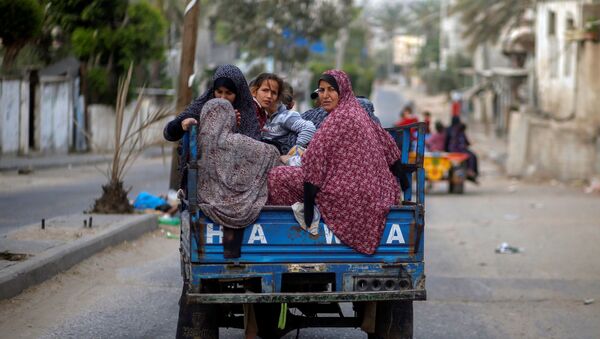 Người Palestine trên xe kéo ô tô chạy khỏi nhà của họ trong các cuộc không kích và pháo binh của Israel - Sputnik Việt Nam