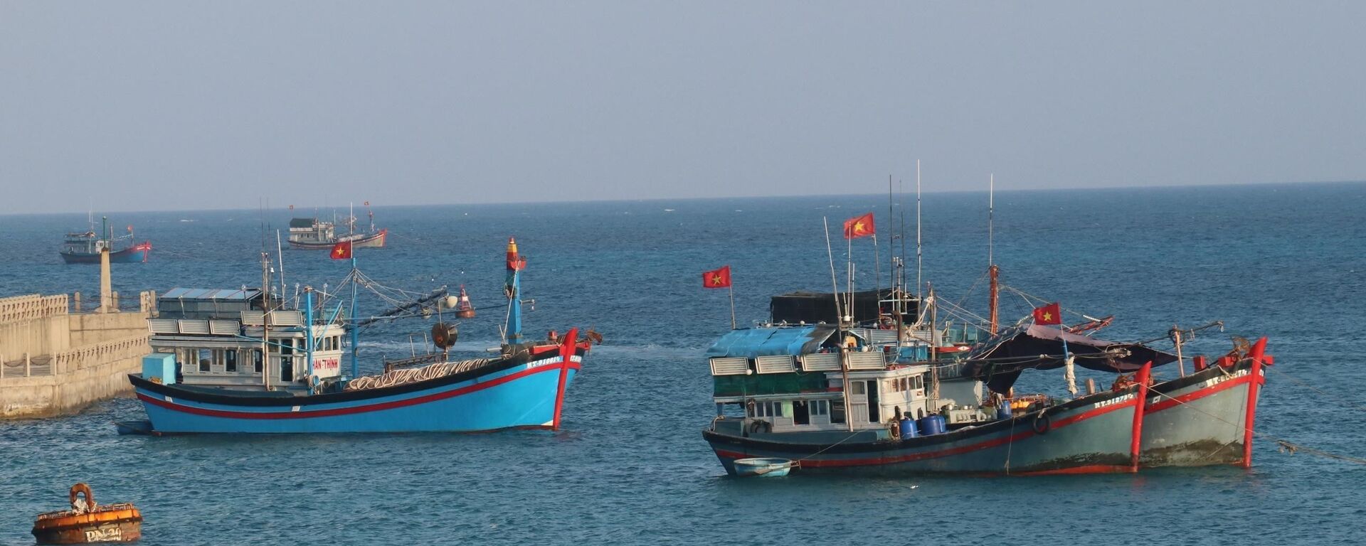 Cờ Tổ quốc tung bay phấp phới trên nóc tàu đánh cá của ngư dân Việt Nam neo đậu tại đảo Đá Tây A (quần đảo Trường Sa). - Sputnik Việt Nam, 1920, 11.07.2022