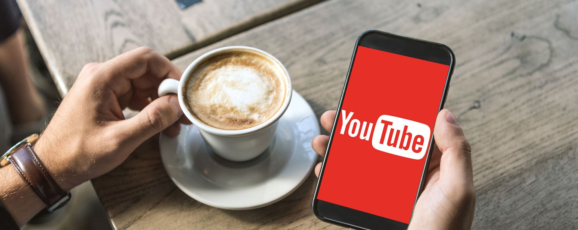 Điện thoại thông minh có logo YouTube và cốc cà phê - Sputnik Việt Nam, 1920, 23.10.2022