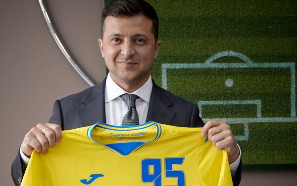 Tổng thống Ukraina Vladimir Zelensky đang cầm chiếc áo thiết kế kiểu mới của đội tuyển quốc gia Ukraina tại Giải vô địch bóng đá châu Âu EURO 2020. - Sputnik Việt Nam