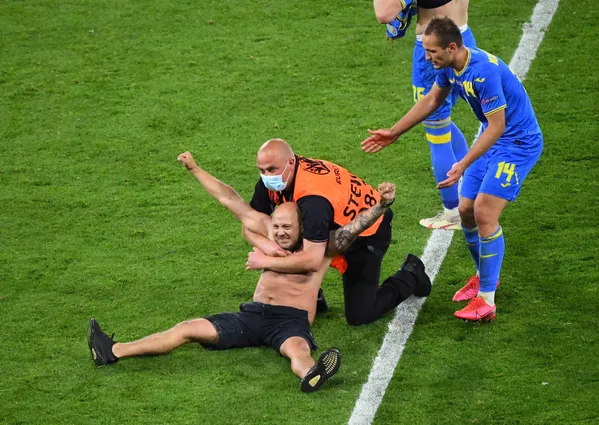 Nhân viên an ninh với một người đàn ông chạy vào sân trong trận Thụy Điển-Ukraina tại UEFA EURO 2020 Nhân viên an ninh với một người đàn ông chạy vào sân trong trận Thụy Điển-Ukraina tại UEFA EURO 2020 - Sputnik Việt Nam