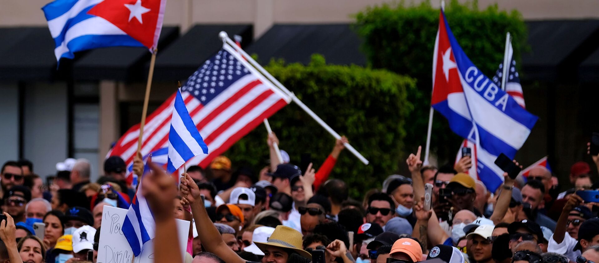 Emigres in Little Havana wave American and Cuban flags as they react to reports of protests in Cuba against the deteriorating economy, in Miami, Florida, U.S., July 11, 2021 - Sputnik Việt Nam, 1920, 15.07.2021