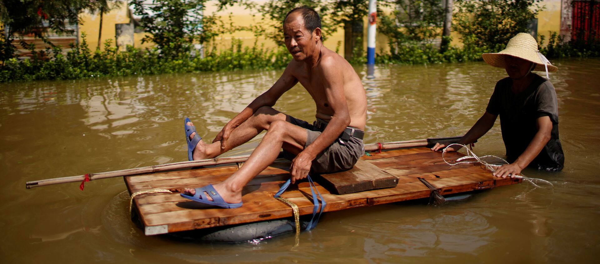 Dân làng băng qua dòng nước lũ sau trận mưa lớn tại một ngôi làng ở Tân Hương, tỉnh Hà Nam, Trung Quốc - Sputnik Việt Nam, 1920, 30.07.2021