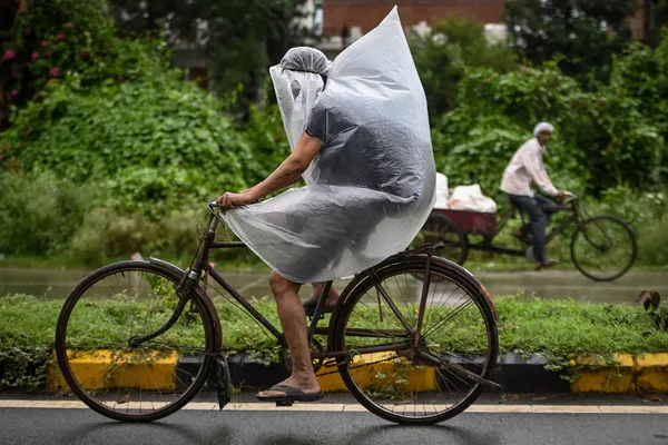 Một người đi xe đạp dùng túi nhựa che trong trận mưa ở Faridabad, Ấn Độ Một người đi xe đạp dùng túi nhựa che trong trận mưa ở Faridabad, Ấn Độ - Sputnik Việt Nam