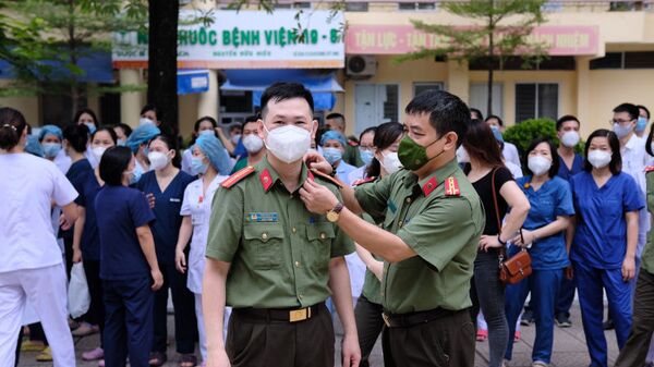 Tranh thủ chỉnh trang trang phục cho đồng đội trước giờ xuất phát lên đường vào tâm dịch TP Hồ Chí Minh. - Sputnik Việt Nam