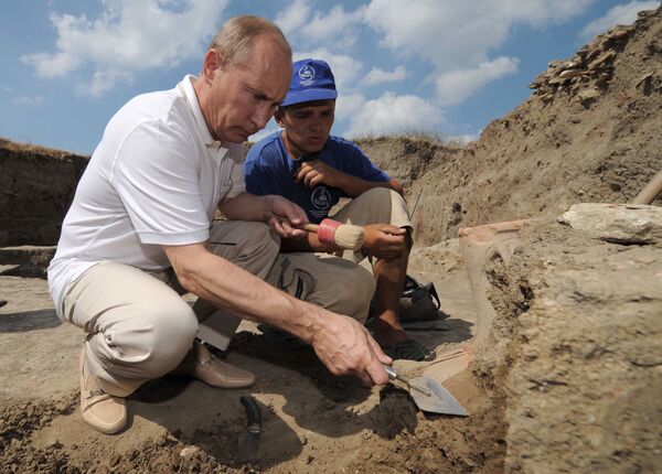 Tháng 8 năm 2011. Thủ tướng Nga Vladimir Putin (trái), đến thăm trại của các nhà khảo cổ học đang khai quật thành phố thời Hy Lạp cổ đại Phanagoria, dọn dẹp một ngôi đền cổ - Sputnik Việt Nam