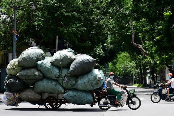 Tiểu thương vận chuyển bao tải trên chiếc xe máy chở hàng tự chế ở Hà Nội - Sputnik Việt Nam