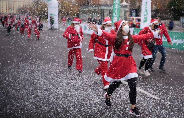 Những người trong trang phục ông già Noel tham gia cuộc chạy từ thiện gây quỹ giúp đỡ nạn nhân vụ phun trào núi lửa Cumbre Vieja ở Madrid, Tây Ban Nha - Sputnik Việt Nam