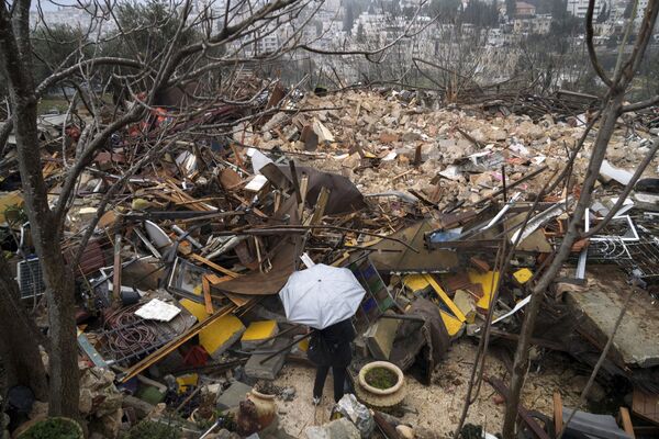 Người phụ nữ nhìn đống gạch vụn của ngôi nhà Palestine bị phá dỡ bởi Thành phố Jerusalem ở khu Sheikh Jarrah ở phía đông Jerusalem - Sputnik Việt Nam