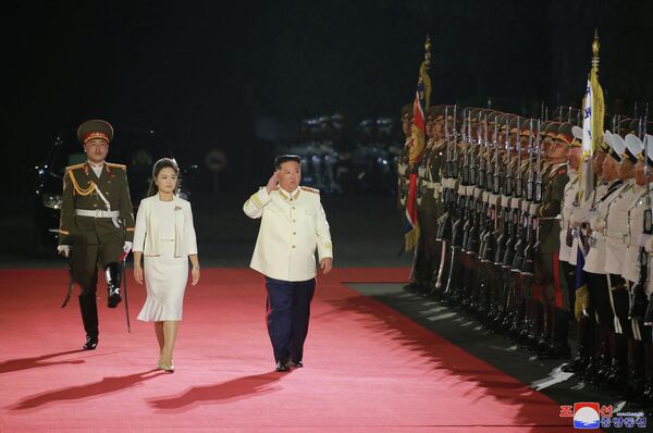 Chủ tịch Bắc Triều Tiên Kim Jong-un và phu nhân trong cuộc duyệt binh nhân kỷ niệm 90 năm Ngày thành lập Quân đội Cách mạng Nhân dân Triều Tiên trên Quảng trường Kim Nhật Thành ở Bình Nhưỡng - Sputnik Việt Nam