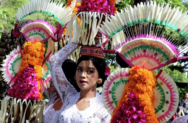 Một phụ nữ mang đồ cúng trong lễ khai mạc Lễ hội Nghệ thuật Bali, Indonesia, Chủ nhật, ngày 12 tháng 6 năm 2022. - Sputnik Việt Nam