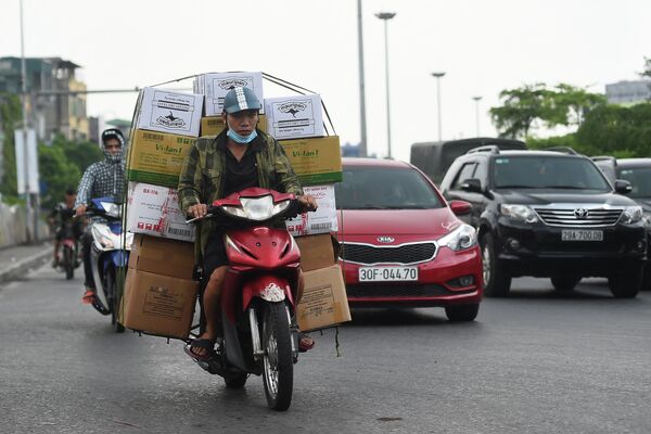 Tài xế chở hàng trên xe máy ở Hà Nội. - Sputnik Việt Nam