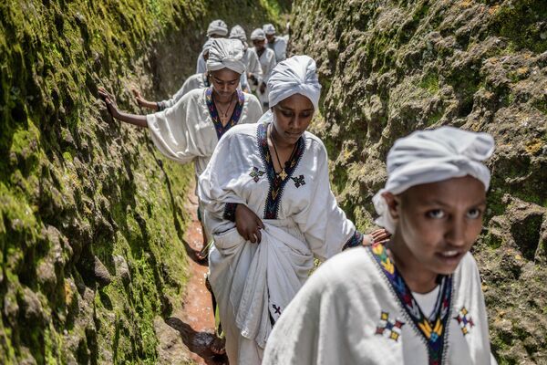 Những người phụ nữ đi bộ qua hang động Thánh George trong lễ hội Ashendha ở Lalibela, Ethiopia. - Sputnik Việt Nam