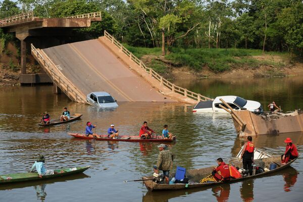 Người dân địa phương và lực lượng cứu hộ tìm kiếm những người rơi xuống sông Curuca sau khi cây cầu bị sập ở Careiro da Varzea, Brazil. - Sputnik Việt Nam