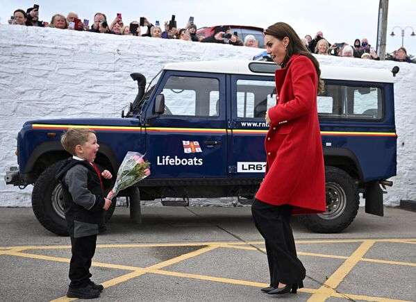 Theo Crompton, 4 tuổi, tặng một bó hoa cho Catherine, Công nương xứ Wales trong chuyến thăm Viện Cứu hộ Quốc gia Hoàng gia ở Anglesey, Wales. - Sputnik Việt Nam