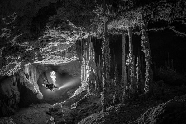 Bức ảnh của nhà nhiếp ảnh Mexico Tom St George, chiến thắng trong hạng mục Ocean Adventure Photographer of the Year tại cuộc thi Ocean Photographer of the Year 2022. Một thợ lặn khảo sát hệ thống hang động dưới nước, được bao quanh bởi những cấu trúc khổng lồ đã mất hàng thiên niên kỷ để hình thành. - Sputnik Việt Nam