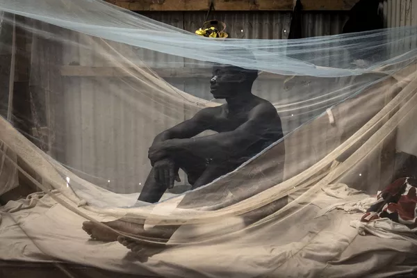 Người thợ xây dựng từ Sierra Leone ngồi trên giường của mình trong lán trại ở Diamniadio. Người thợ xây dựng từ Sierra Leone ngồi trên giường của mình trong lán trại ở Diamniadio. - Sputnik Việt Nam