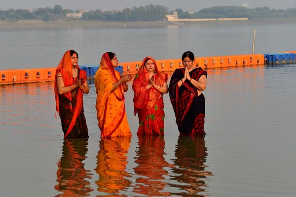 Phụ nữ Ấn Độ thực hiện nghi lễ tôn giáo đêm trước lễ hội Chhat Puja ở Prayagraj. - Sputnik Việt Nam