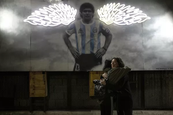 Phụ nữ ôm nhau khi gặp gỡ bên bức ảnh của Diego Maradona ở Buenos Aires. Phụ nữ ôm nhau khi gặp gỡ bên bức ảnh của Diego Maradona ở Buenos Aires. - Sputnik Việt Nam