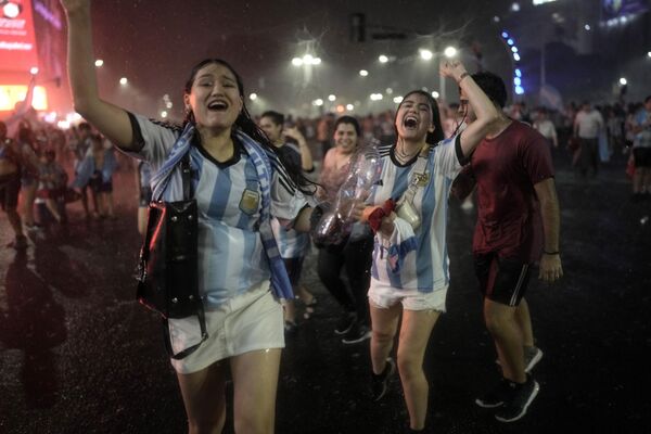 Ở Buenos Aires (Argentina), người hâm mộ bóng đá Argentina ăn mừng chiến thắng của đội tuyển trong trận tứ kết Giải vô địch bóng đá thế giới 2022. - Sputnik Việt Nam