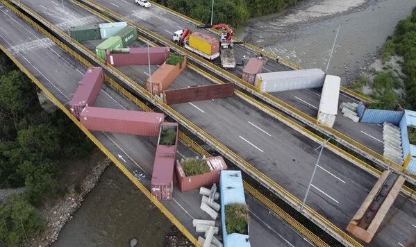 Nhân viên người Venezuela làm sạch các thùng chứa ở Cucuta, Colombia. - Sputnik Việt Nam