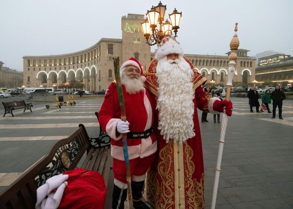 Ông già Tuyết từ Veliky Ustyug và Santa Claus (trái) trên Quảng trường Cộng hòa ở Yerevan. - Sputnik Việt Nam