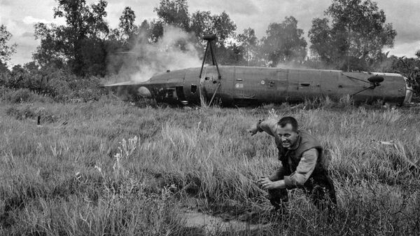 Lính Mỹ chạy xa khỏi chiếc trực thăng CH-21 Shawnee rơi ở miền Nam Việt Nam - Sputnik Việt Nam