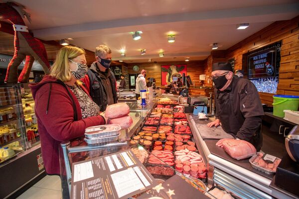 Người bán thịt Kieran McAthumney phục vụ khách hàng trong quầy tại cửa hàng bán thịt của mình ở Ballymena, Bắc Ireland. Người bán thịt Kieran McAthumney phục vụ khách hàng trong quầy tại cửa hàng bán thịt của mình ở Ballymena, Bắc Ireland. - Sputnik Việt Nam