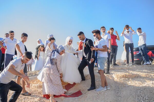 Cặp tân hôn người Thổ Nhĩ Kỳ ngồi thuyền trong lễ cưới để tiến hành chuyến tham quan hồ nước bị ngập ở thành phố cổ Hasankeyf. - Sputnik Việt Nam