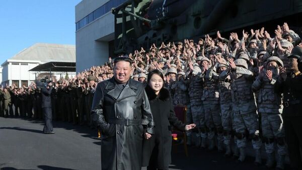 Nhà lãnh đạo Triều Tiên Kim Jong-un và con gái chụp ảnh cùng các công nhân ngành công nghiệp quốc phòng đang làm việc trong vụ phóng tên lửa đạn đạo xuyên lục địa Hwaseong-17 - Sputnik Việt Nam