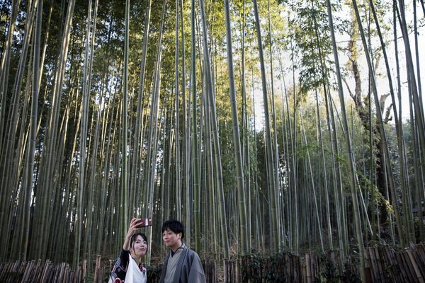 Khách du lịch mặc kimono chụp ảnh tự sướng trong Rừng tre Sagano ở Arashiyama, Quận Kyoto của Nhật Bản. - Sputnik Việt Nam