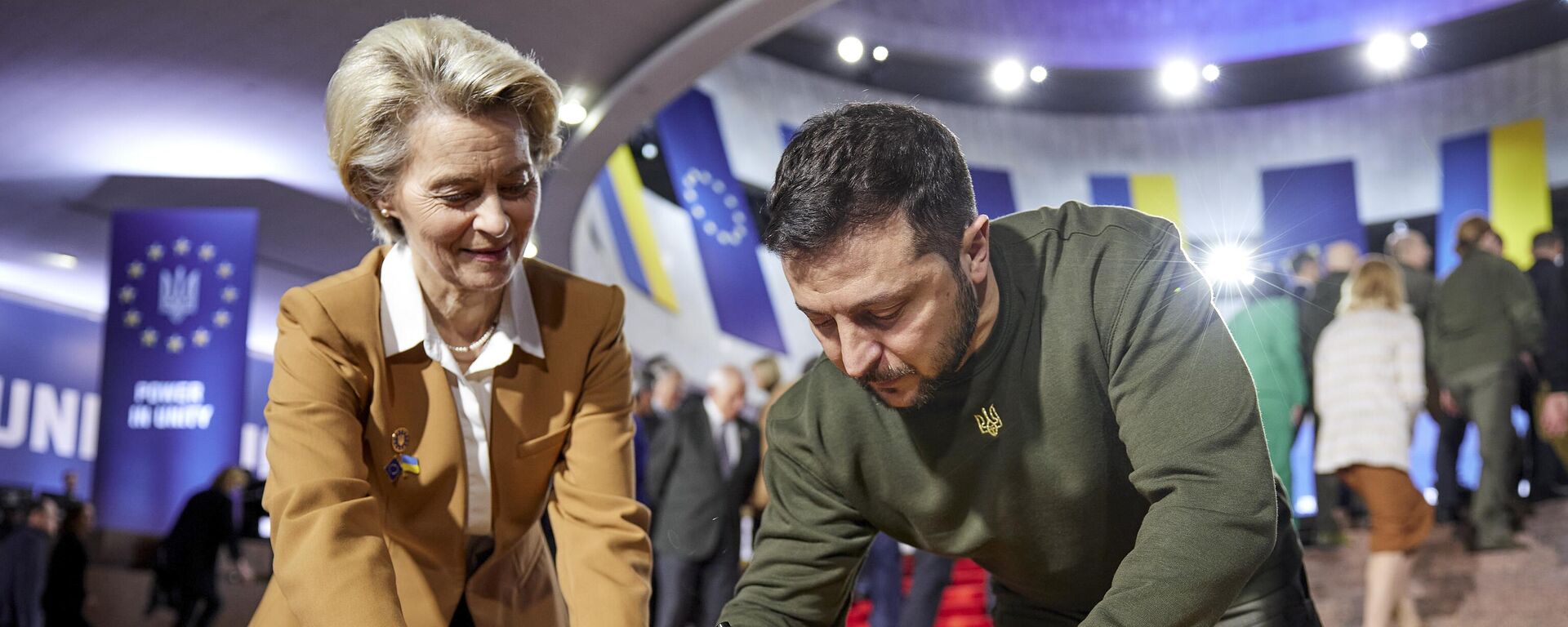 Tổng thống Ukraina Vladimir Zelensky (phải) và Chủ tịch Ủy ban châu Âu Ursula von der Leyen viết lời chúc trên lá cờ Ukraina trong hội nghị thượng đỉnh Ukraina-EU ở Kiev. - Sputnik Việt Nam, 1920, 19.11.2025