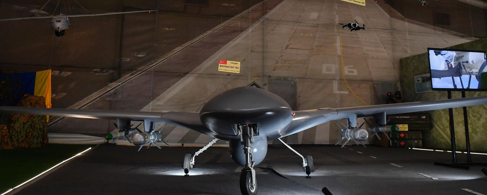 Những chiếc máy bay không người lái bị bắn hạ trong chiến dịch quân sự đặc biệt ở Ukraina được trưng bày tại Diễn đàn kỹ thuật quân sự quốc tế Army 2022. Ở giữa gian trưng bày là UAV Bayraktar TB2 của Thổ Nhĩ Kỳ bị bắn rơi tại khu vực dân cư Svyatovo thuộc LNR. - Sputnik Việt Nam, 1920, 16.04.2026