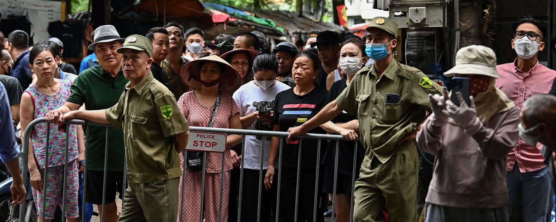 Cư dân đứng sau rào chắn bên cạnh hiện trường vụ cháy chung cưmini ở Hà Nội. - Sputnik Việt Nam, 1920, 14.09.2023