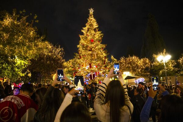 Du khách dùng điện thoại thông minh chụp cây thông Noel ở Athens, Hy Lạp - Sputnik Việt Nam