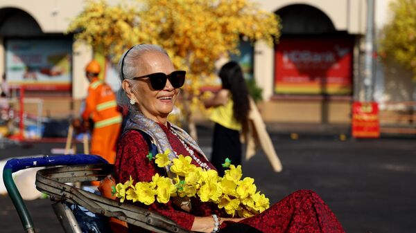 Người dân Thành phố Hồ Chí Minh chụp ảnh đón chào năm mới Giáp Thìn 2024 trước chợ Bến Thành. - Sputnik Việt Nam