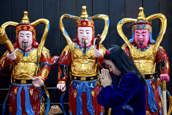 Một người phụ nữ cầu nguyện trong ngày lễ tình nhân tại chùa Hà ở Hà Nội, Việt Nam. - Sputnik Việt Nam