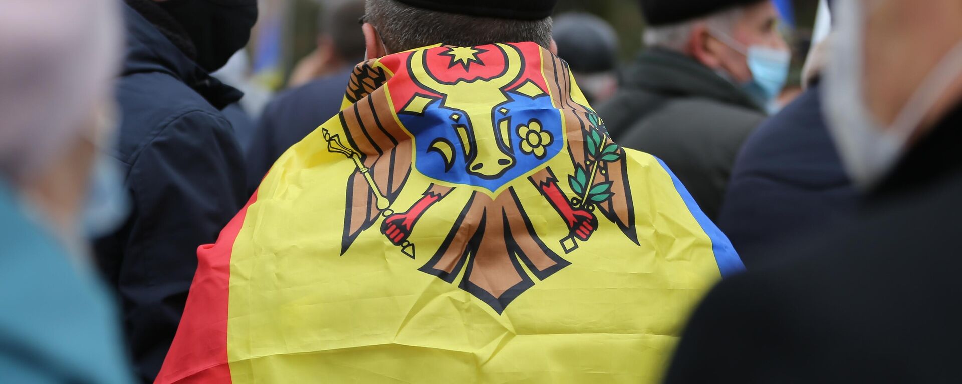 Cờ Moldova khoác trên lưng người tham gia mít tinh cạnh tòa nhà quốc hội Moldova để ủng hộ Tổng thống mới đắc cử Maia Sandu  - Sputnik Việt Nam, 1920, 28.09.2025