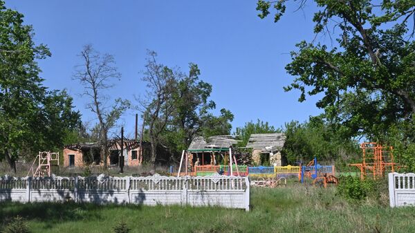 Sân chơi trẻ em bị hư hại do pháo kích ở làng Tavolzhanka, tỉnh Kharkov - Sputnik Việt Nam