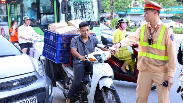 Chiến sĩ thuộc Tổ công tác đặc biệt Công an TP Hà Nội dừng xe, kiểm tra và xử lý 1 trường hợp vi phạm trật tự an toàn giao thông tại tuyến phố Ô Chợ Dừa, quận Đống Đa.  - Sputnik Việt Nam