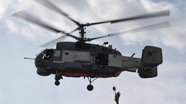 Chiếc máy bay trực thăng tìm kiếm-cứu hộ Ka-27 PS nâng một hình nộm lên khoang khi thực hành nhiệm vụ giải cứu nạn nhân trong chuyến bay huấn luyện tại căn cứ đồn trú hàng không Nikolaevka của Hạm đội Thái Bình Dương ở Lãnh thổ Primorsky - Sputnik Việt Nam