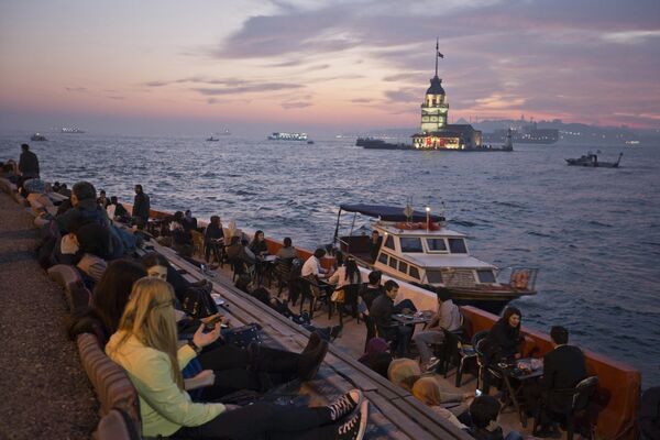 Người dân tận hưởng thời tiết ấm áp phía trên Tháp Maiden trên eo biển Bosphorus ở Istanbul, Thổ Nhĩ Kỳ - Sputnik Việt Nam