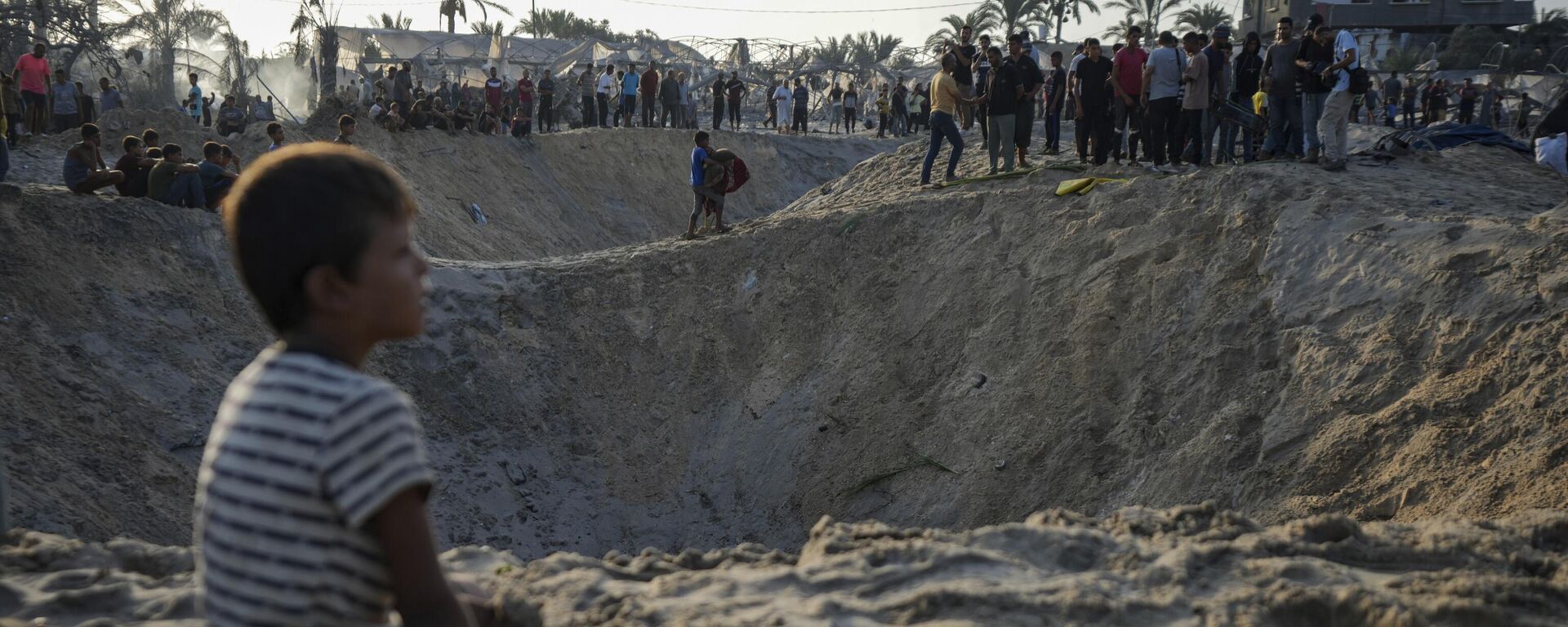 Người dân Palestine đứng nhìn cảnh khu lều trại của mình bị tàn phá sau cuộc không kích của Israel - Sputnik Việt Nam, 1920, 06.02.2025