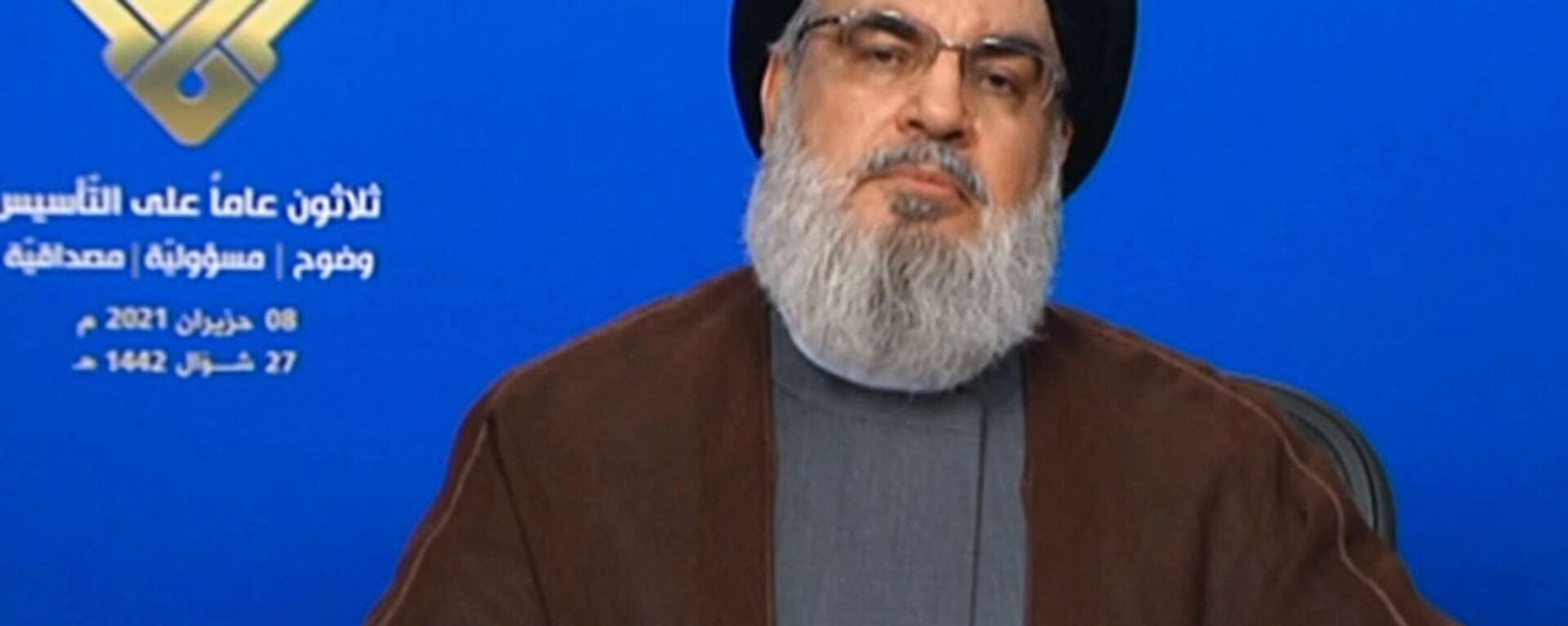 An image grab taken from Hezbollah's al-Manar TV on June 8, 2021, shows the leader of the Lebanese Shiite party Hassan Nasrallah delivering a televised speech from an undisclosed location to mark the anniversary of the TV network. - Sputnik Việt Nam, 1920, 30.09.2024